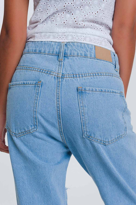 High waist mom jeans with busted knees in light denim