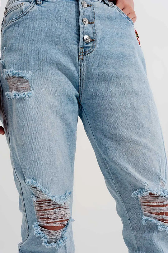 Straight leg distressed jeans with button detail in light blue