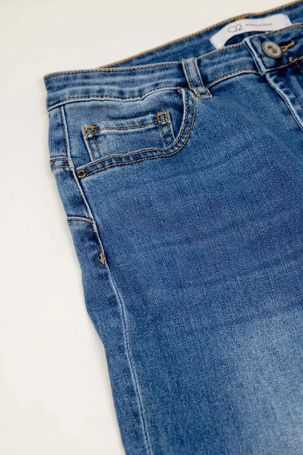 Basic straight jeans with five pockets and frontal metalic button closure