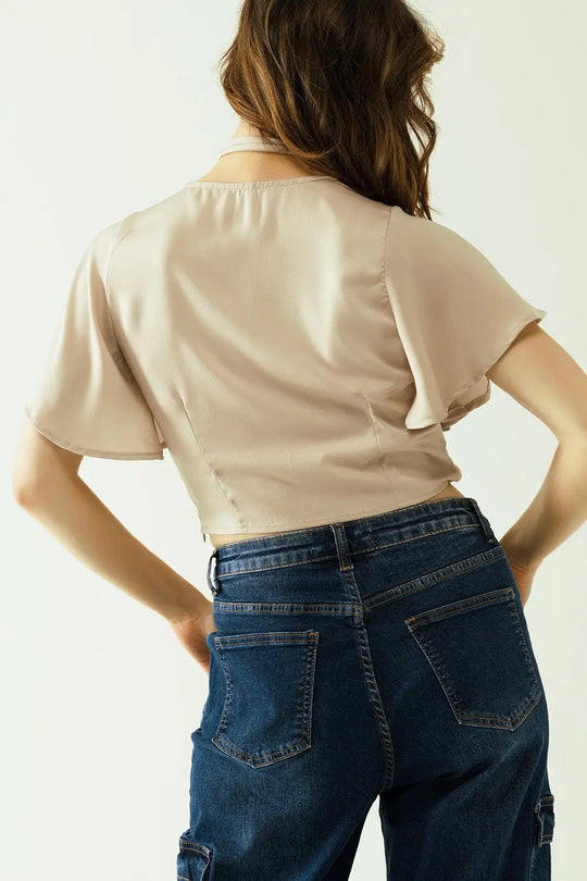 Beige V-neck crop top with short sleeves and a flower detail on the neck - Tops