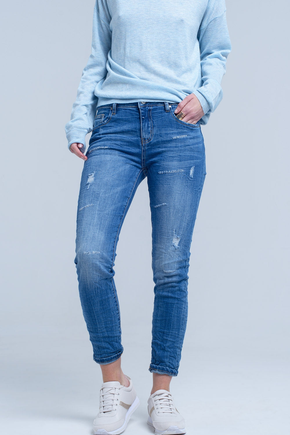 Ankle jeans with rip and repair