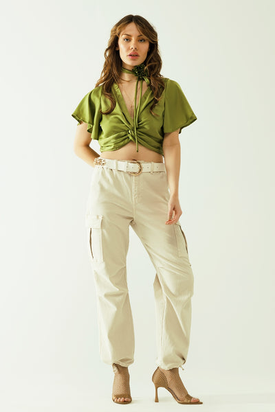 Green V-neck crop top with short sleeves and a flower detail on the neck