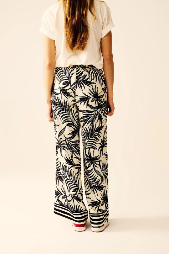 Pantalon à jambes larges en blanc avec détails floraux en noir - Pantalons