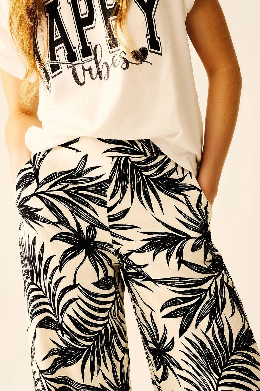 Pantalon à jambes larges en blanc avec détails floraux en noir - Pantalons