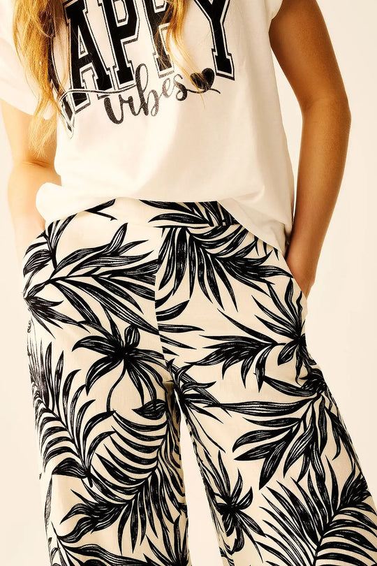 Pantalon à jambes larges en blanc avec détails floraux en noir - Pantalons