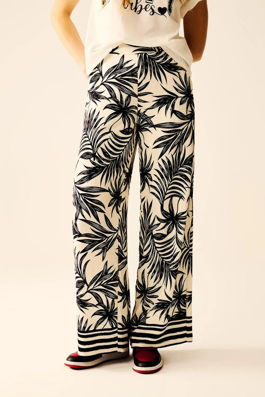 Pantalon à jambes larges en blanc avec détails floraux en noir - Pantalons