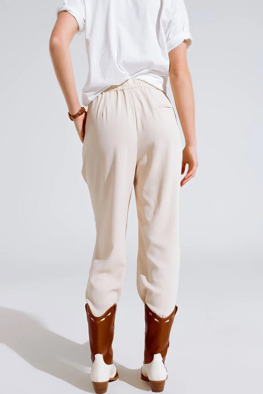 Pantalon en beige avec poches avant et fermeture par cordon de serrage - Pantalons