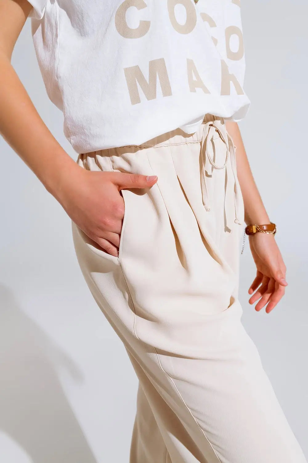 Pantalon en beige avec poches avant et fermeture par cordon de serrage - Pantalons