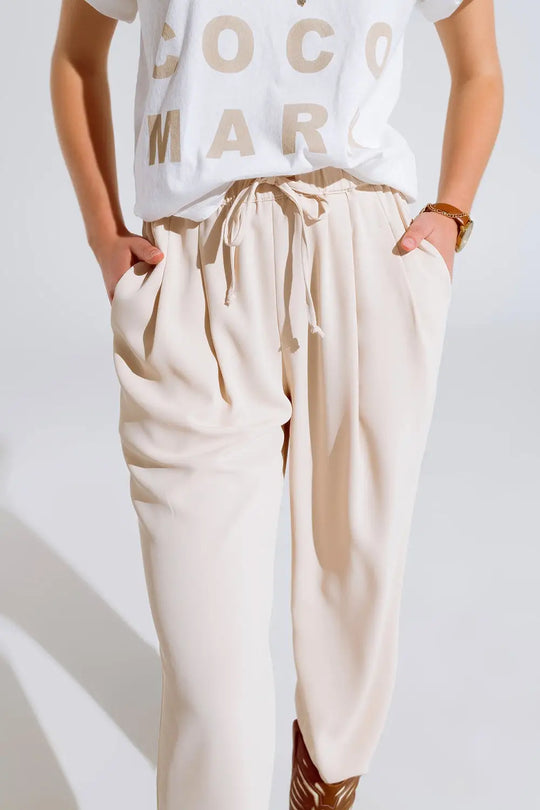 Pantalon en beige avec poches avant et fermeture par cordon de serrage - Pantalons