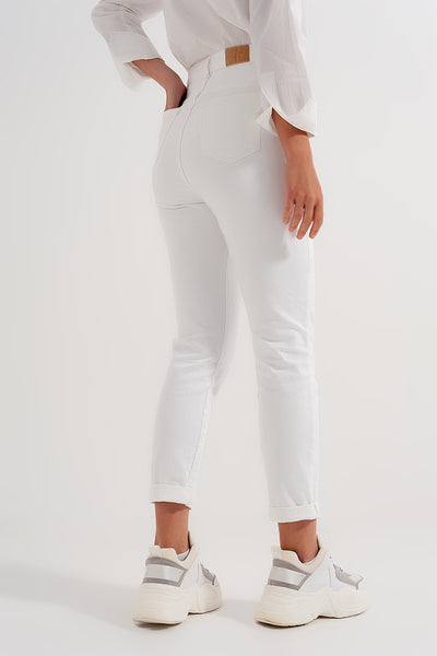 Slim jeans with asymmetric button in cream