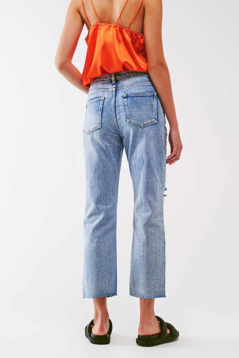 Sraight-leg jeans with exposed buttons and ripped knees in light wash