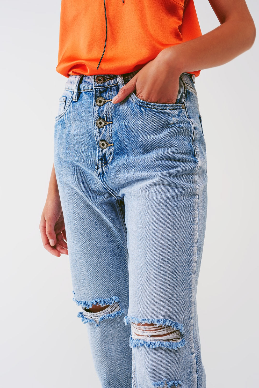 Sraight-leg jeans with exposed buttons and ripped knees in light wash