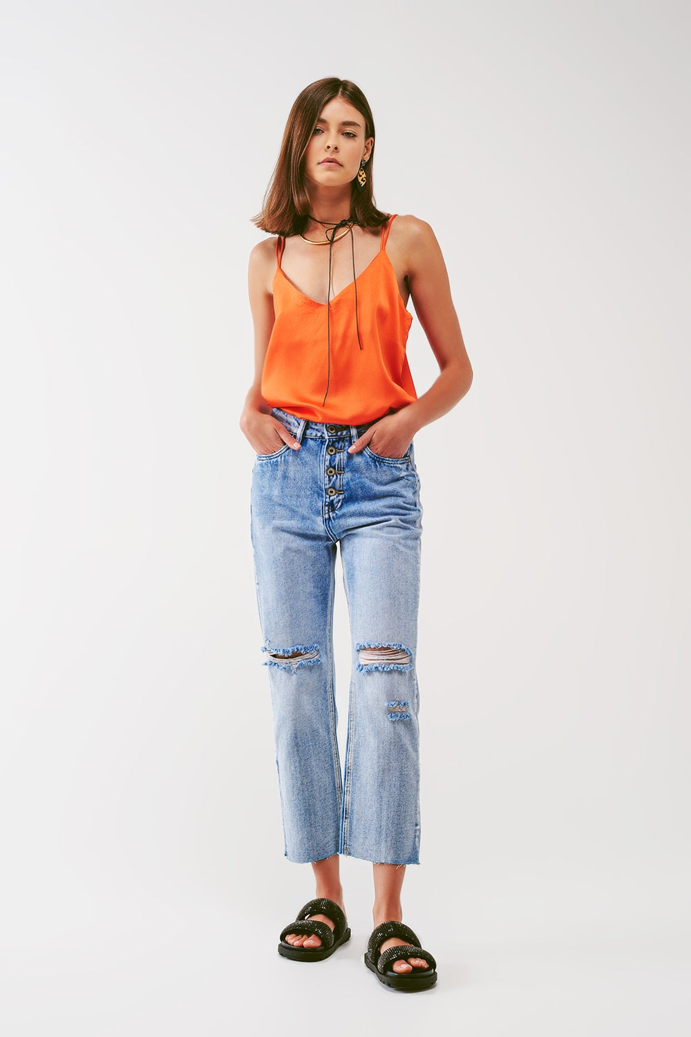 Sraight-leg jeans with exposed buttons and ripped knees in light wash