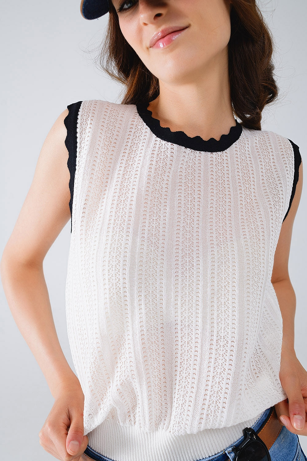 white knitted pointelle top with black wavy trim