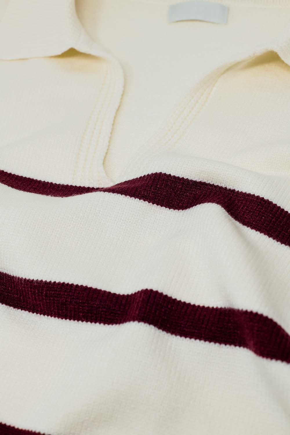 white sweater with dark red stripes and wide v neck